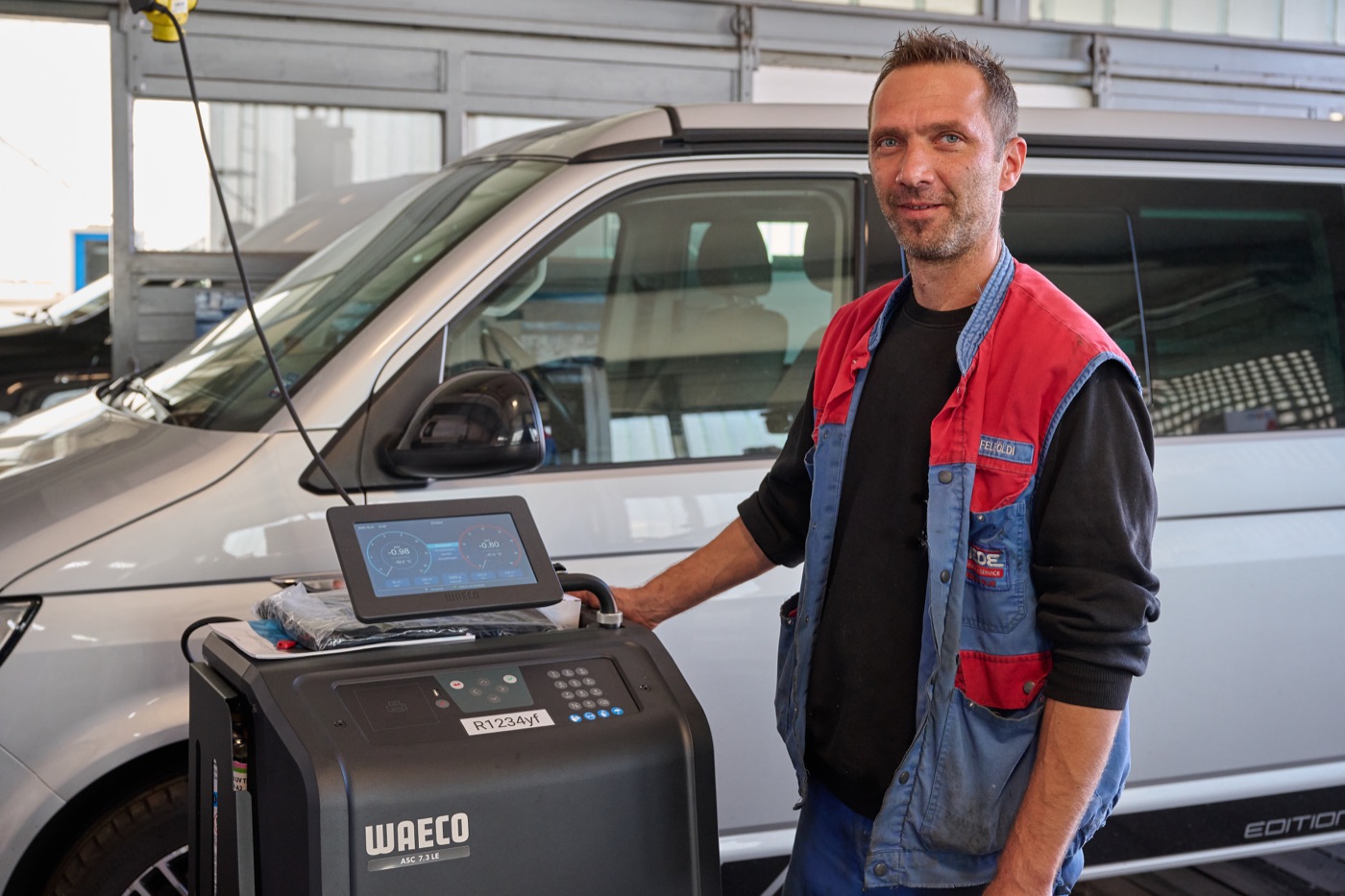 Levente Felföldi am Klimaservice-Gerät in der Werkstätte